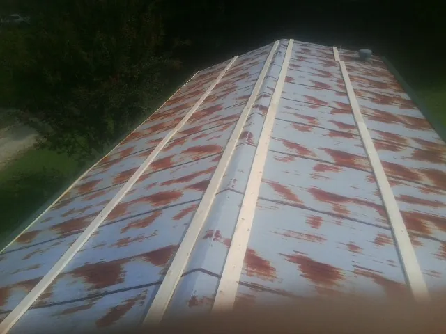 Rusted metal roof panels with new wood purlins before replacement — Storm Damage Roof Repair in Kewanna by Roofing Brothers