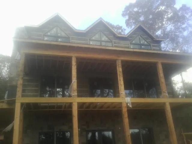 Dormers and porch framing on a large log home under construction — Roof Coating work by our crew in Kewanna